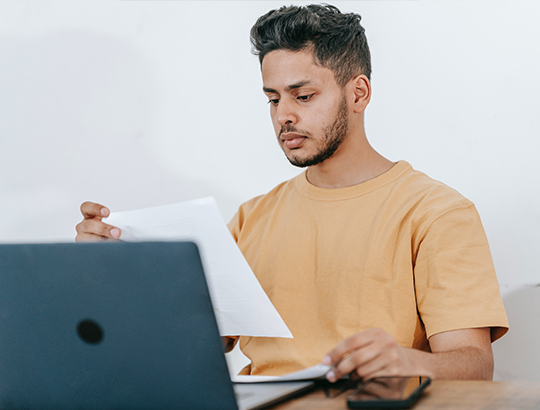 A boy is reading a paper